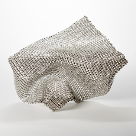 collapsing glass abstract sculpture with the appearance of falling fabric with a very open weave and front face covered in silver