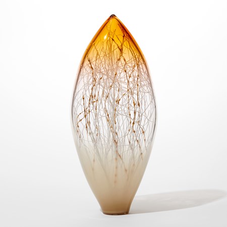 pointed oval transparent glass sculpture with opaque bottom half fading to clear then fading to brilliant gold yellow with organic fine canes trapped inside traversing the interior in white and gold