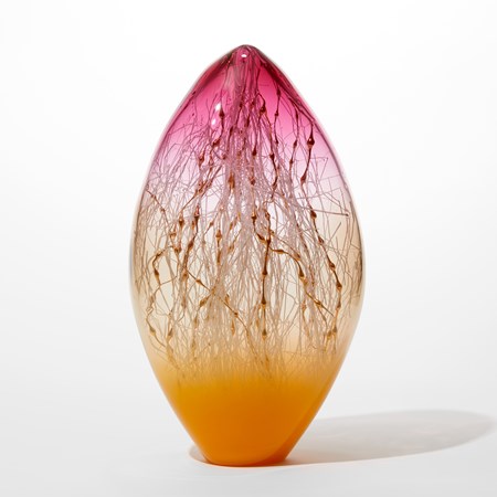 oval transparent glass sculpture with pointed top with opaque bright orange base clear middle and vibrant pink top with white and gold canes inside traversing the hollow space