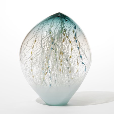 off centre ovoid hand blown glass sculpture with pointed top and opaque celadon base clear middle and transparent teal top with the interior filled with an organic mass of fine canes in white ochre blue and teal