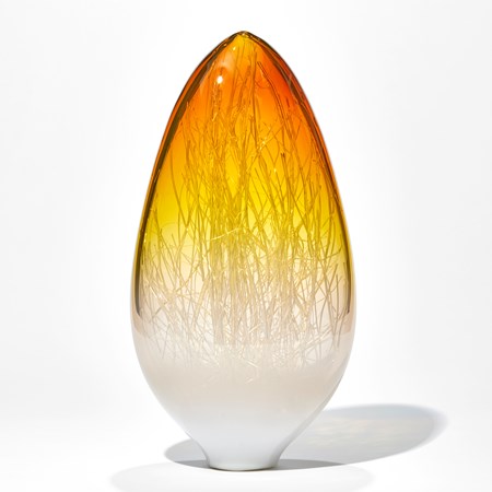 tall sculpted glass vessel in amber and white which wire interior resembling bare tree branches