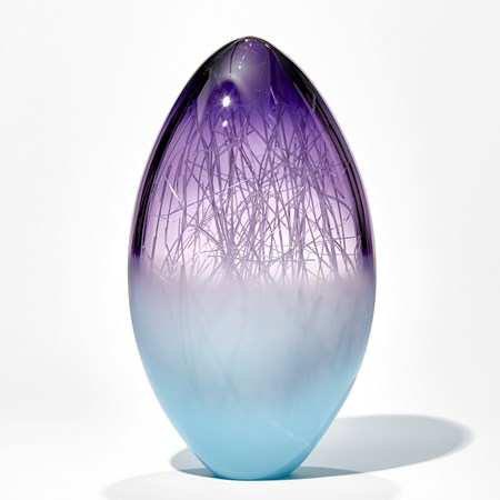 oblong shaped glass sculpture in pale turquoise and indigo with internal wire structure resembling tree branches