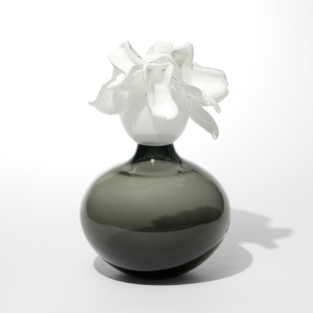 transparent grey squat orb with a floral top section with abstract soft angular opaque white petals hand made from glass