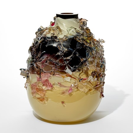 stumpy bottle shaped vessel with flat top edge and bands of colour in off white black and ochre with the exterior covered in organic shards in pink and amber hand made from glass