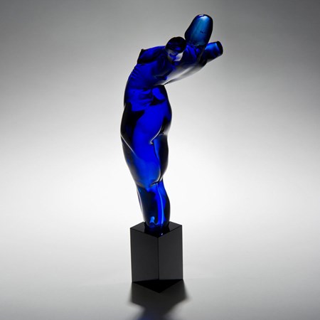 abstract blue glass sculpture of body-like shape on black base