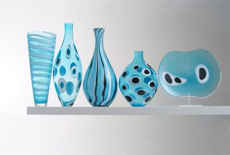 five glass vase sculptures of different sizes in aqua blue 