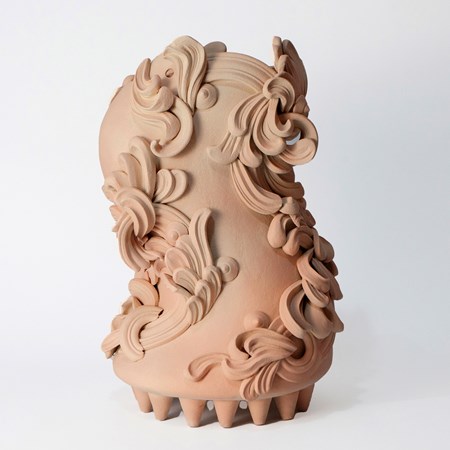 bloated s shaped sculptural vessel in dusty peach pink and beige held aloft on a multitude of small cone shaped feet on the base covered in architectural swirls and curls hand made from white st thomas clay