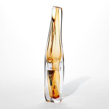 tall sea cucumber shaped vase with narrow top opening and soft twisting fluid lines in clear and light golden amber hand made from glass