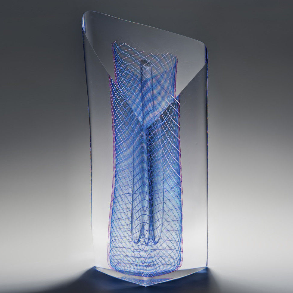 art glass sculpture with blue mesh pattern in dress shape caged in outer clear glass structure