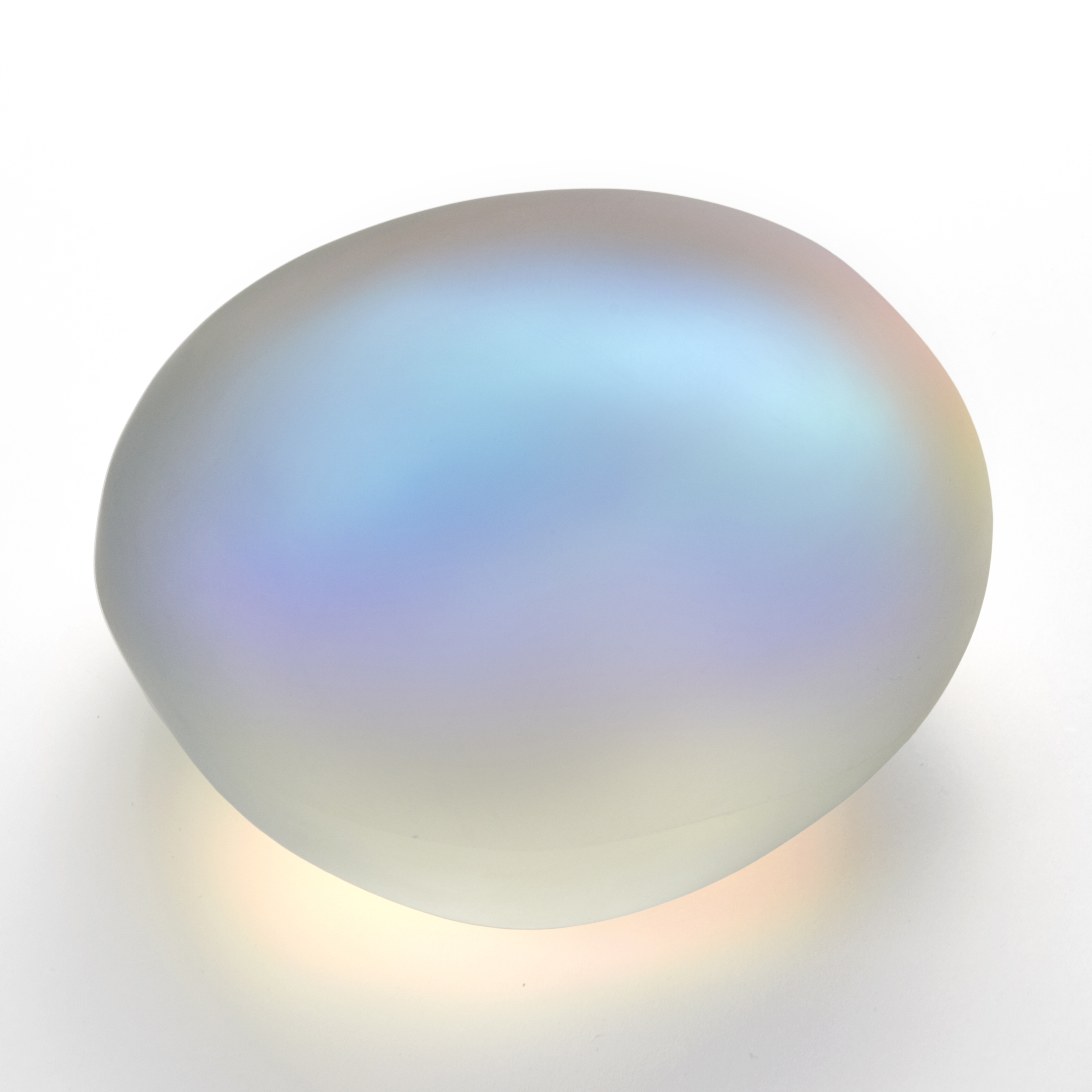 smooth transparent pebble with satin surface and interior emanating an ethereal mix of colours like petrol on water or dragon fly wings hand made from glass