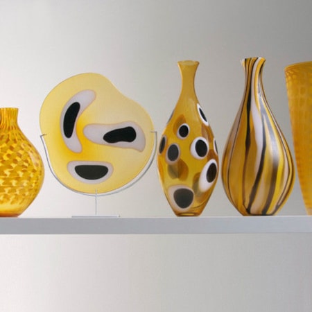 five handblown glass vases in shades of yellow with various patterns