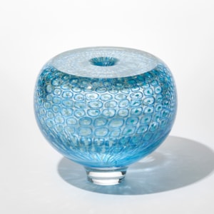 round transparent aquamarine and turquoise vase with incased repeat pattern of rings and dots with a flat shiny top and small central hole hand made from blown glass