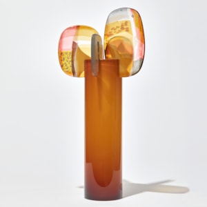 opaque burnt orange shiny cylinder with rounded fins in pink yellow gold pink and grey with abstract patterns perched on the top handmade from glass