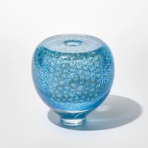 round transparent vase with tapered foot and repeat pattern incased created from small circles and dots in turquoise and celadon hand made from blown glass