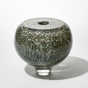 round transparent sea urchin inspired vase with shiny surface and repeat ring and dot pattern trapped within hand made from blown glass