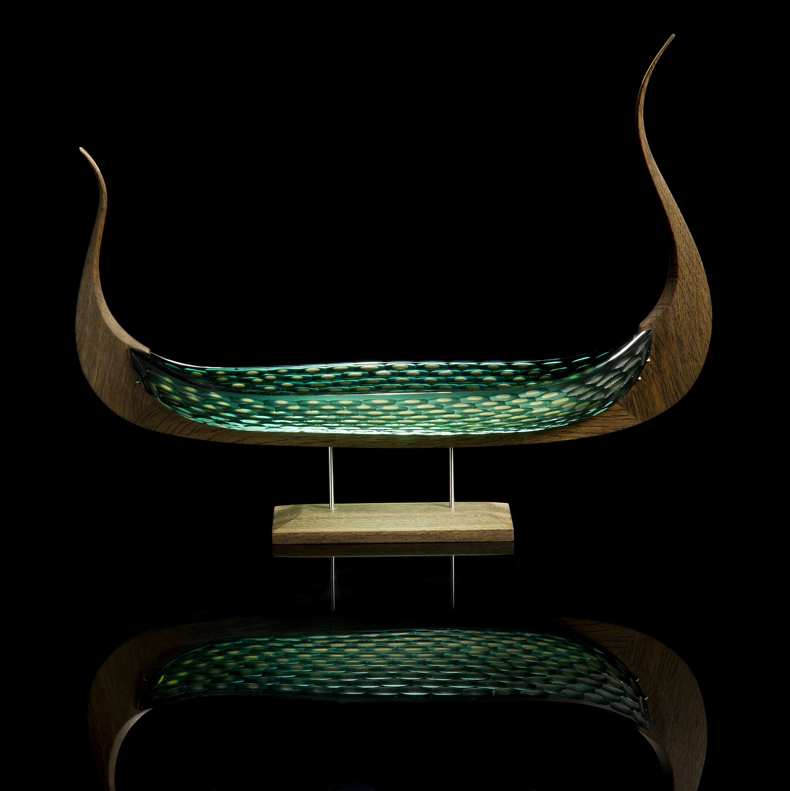 wood and glass sculpture of viking ship in green and brown