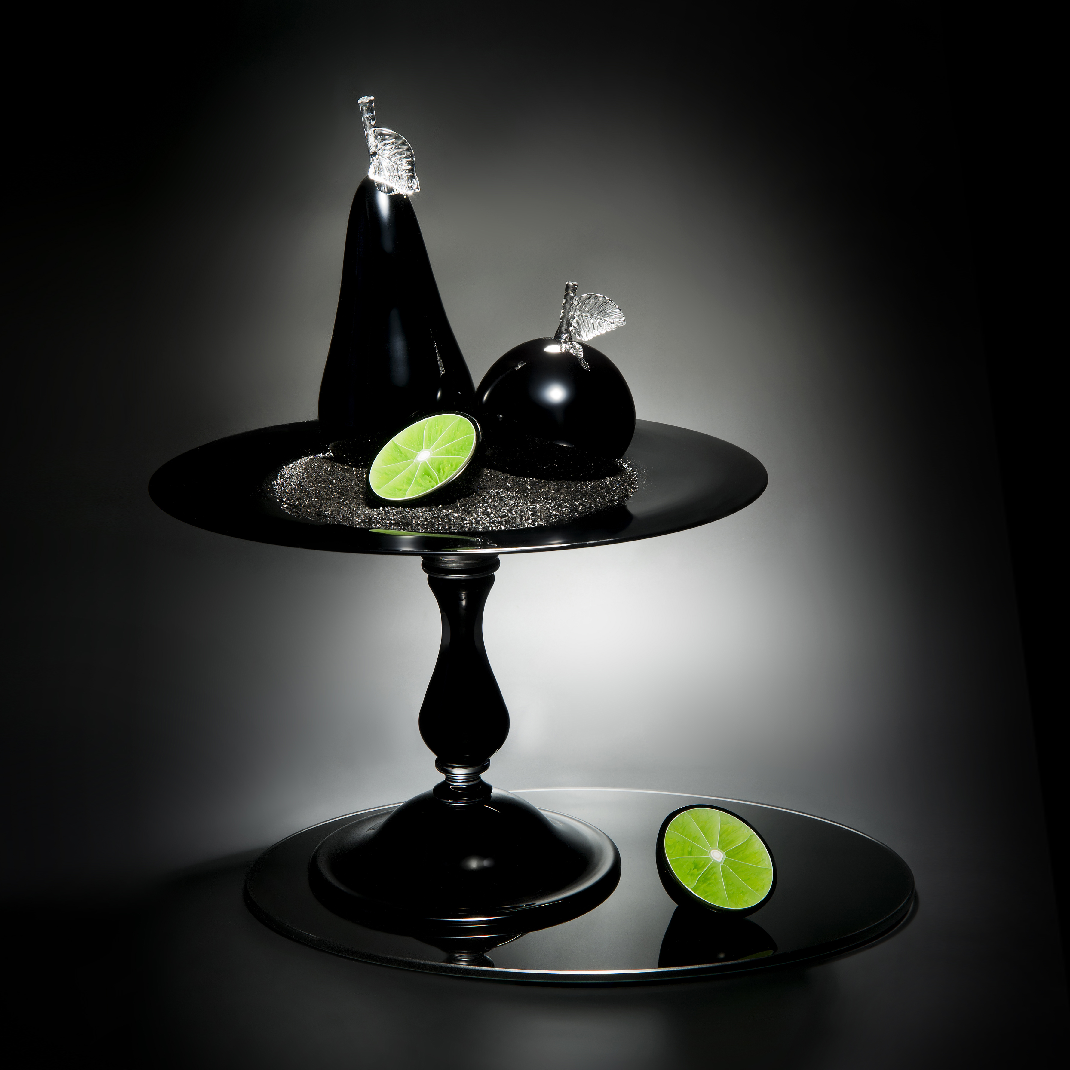 still life sculpted glass scene of cut fruit in black and lime colours