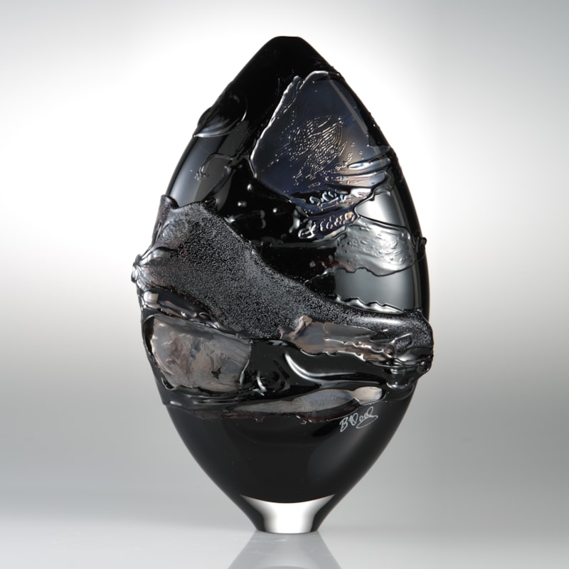 black oval shaped art glass sculptural vessel with gold splashes