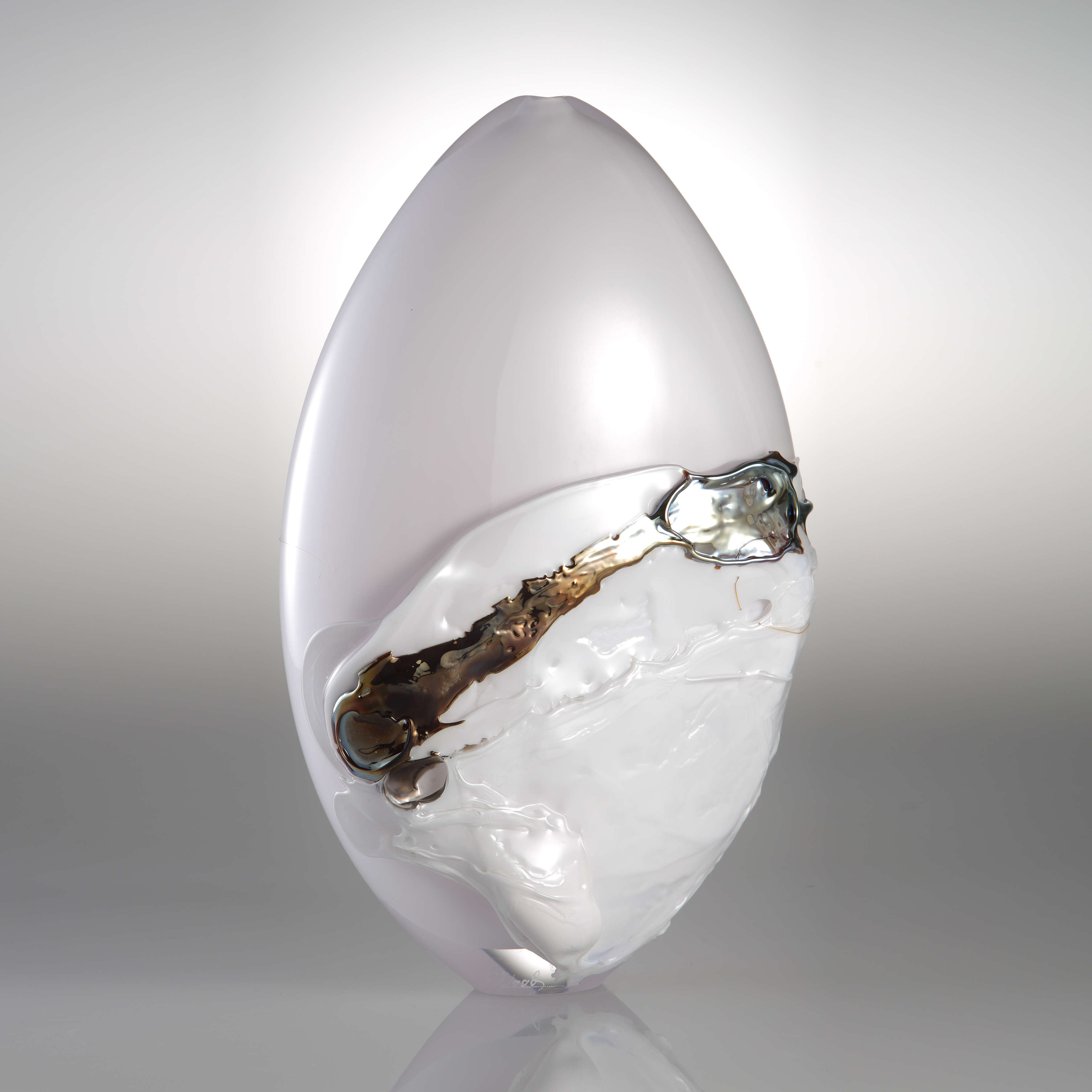 orb shaped art glass sculpture in white with black and gold splashes 