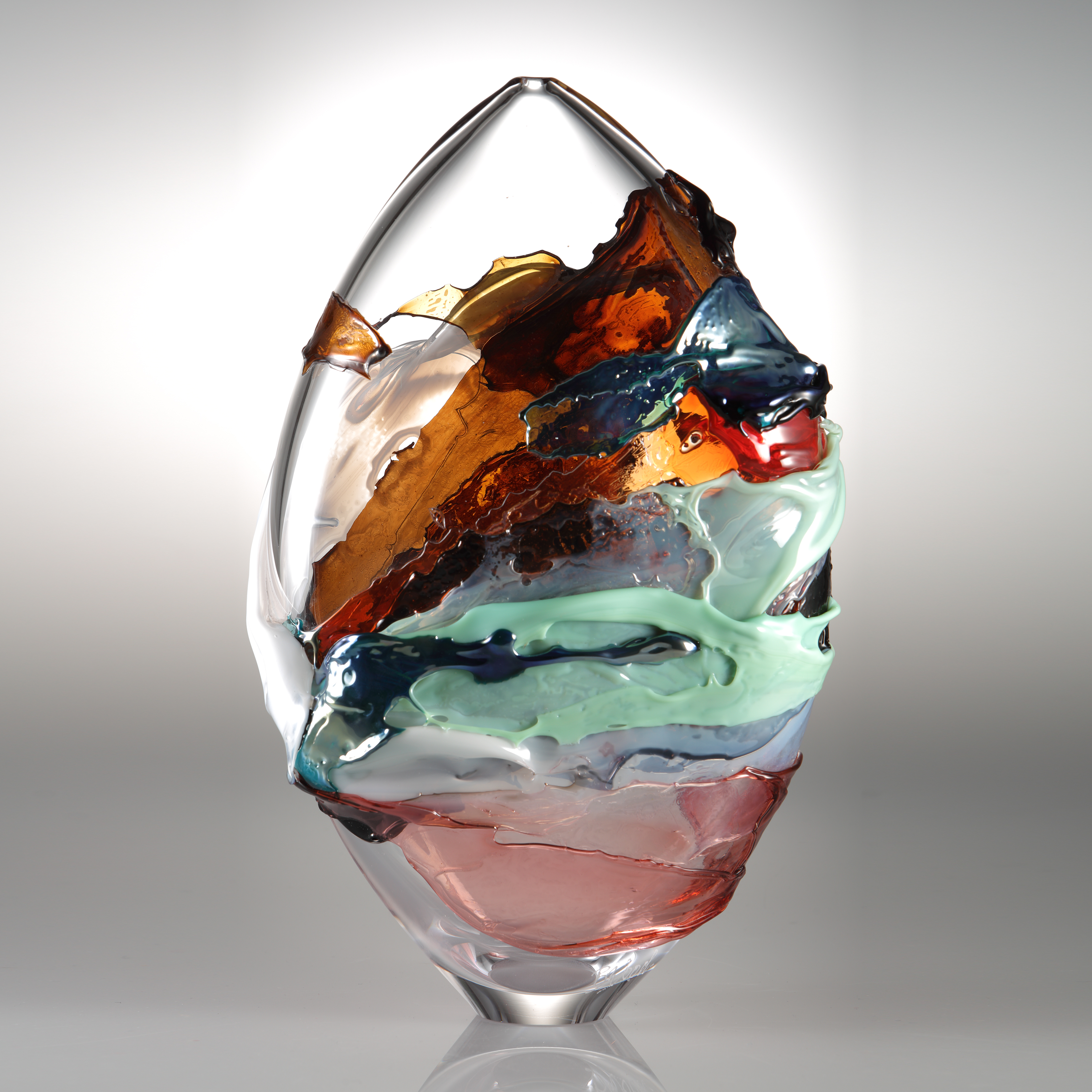 oval shaped blown clear glass vessel with splashes of dark orange light green and pink colour