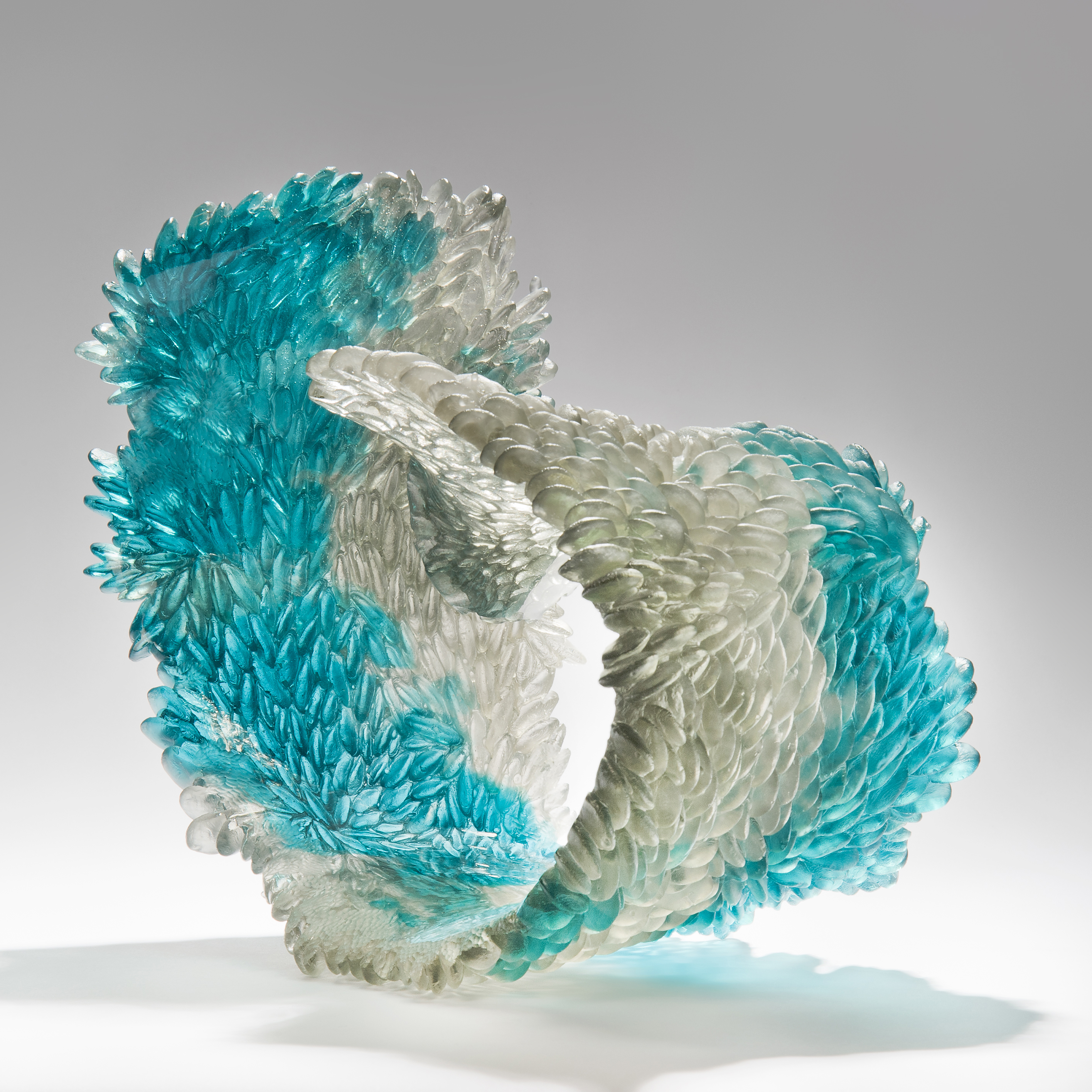 modern art glass sculpture of curled form in turquoise and clear glass