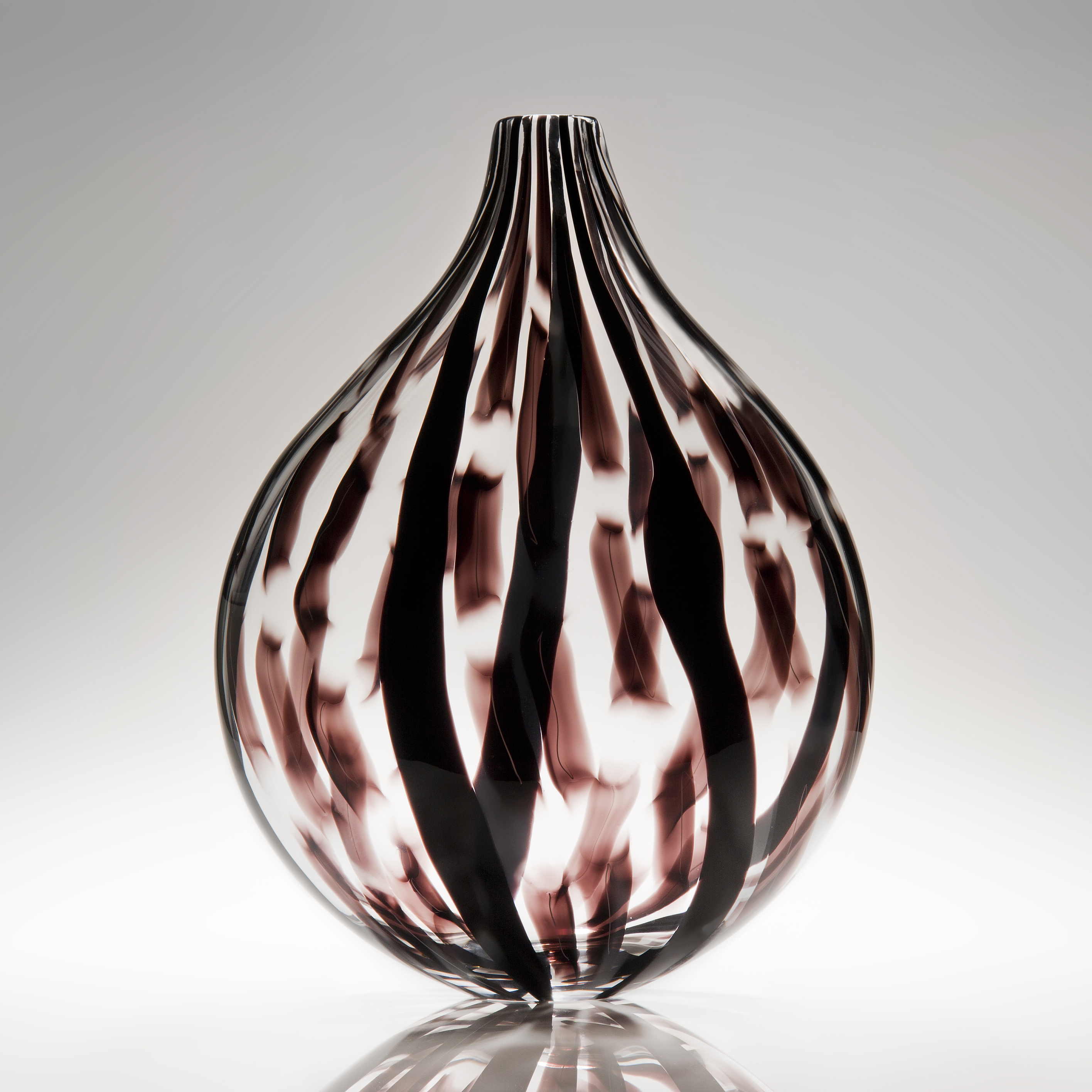 sculpted glass vessel with round base and short neck with black and dark red lined patterns