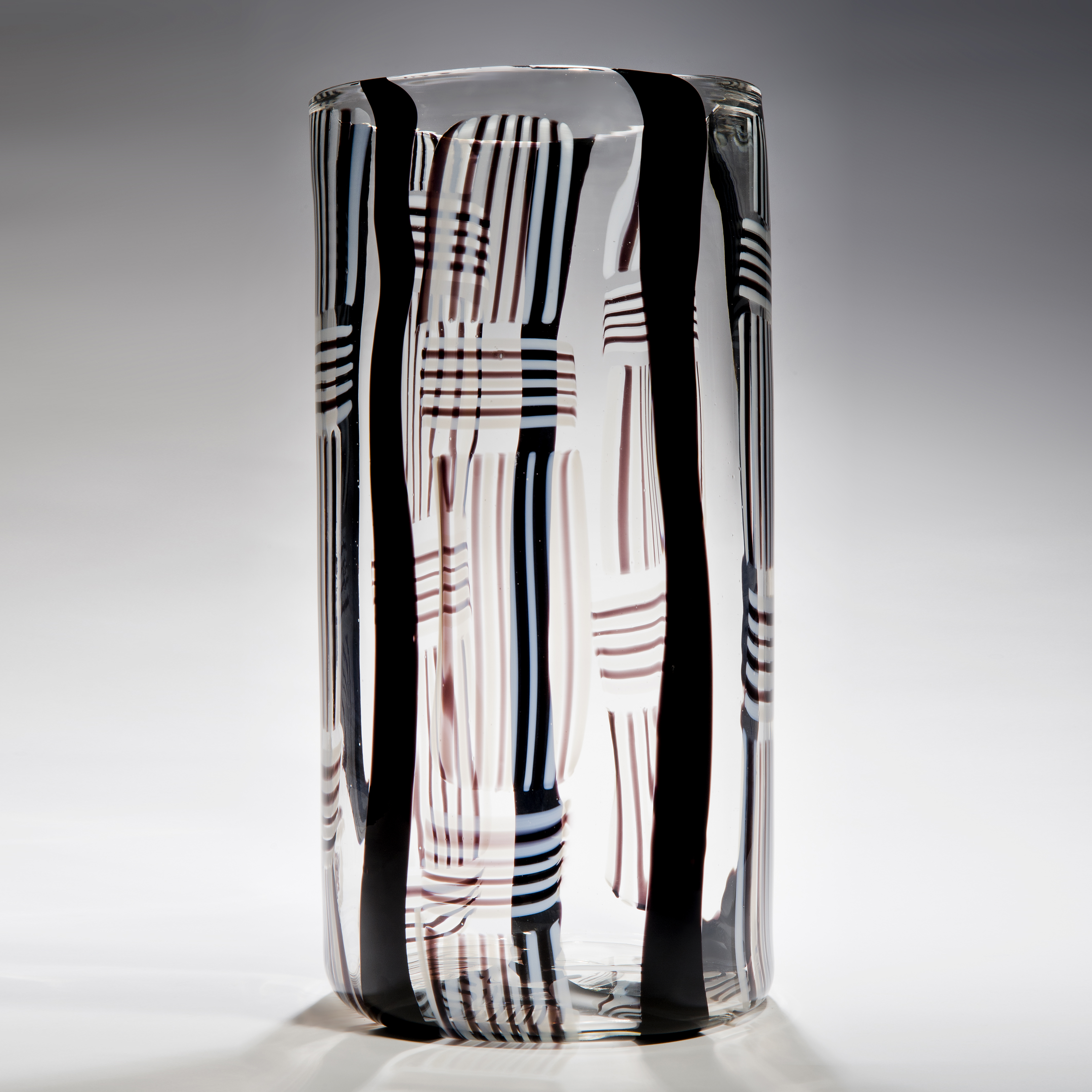 tall rounded and minimalist art glass sculpture in clear glass with black red and white line pattern