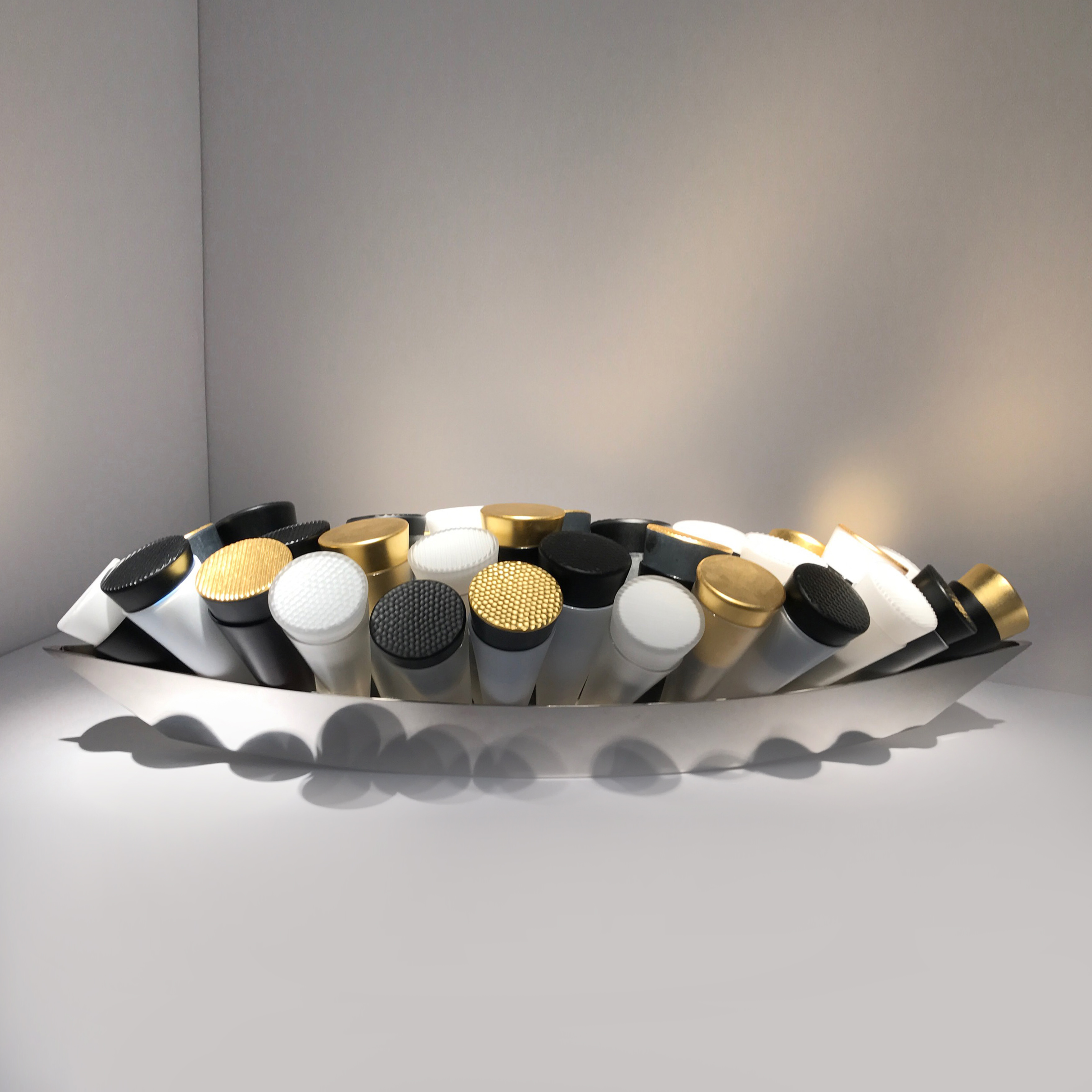 artwork of black white and gold coloured glass tubes in long silver tray.