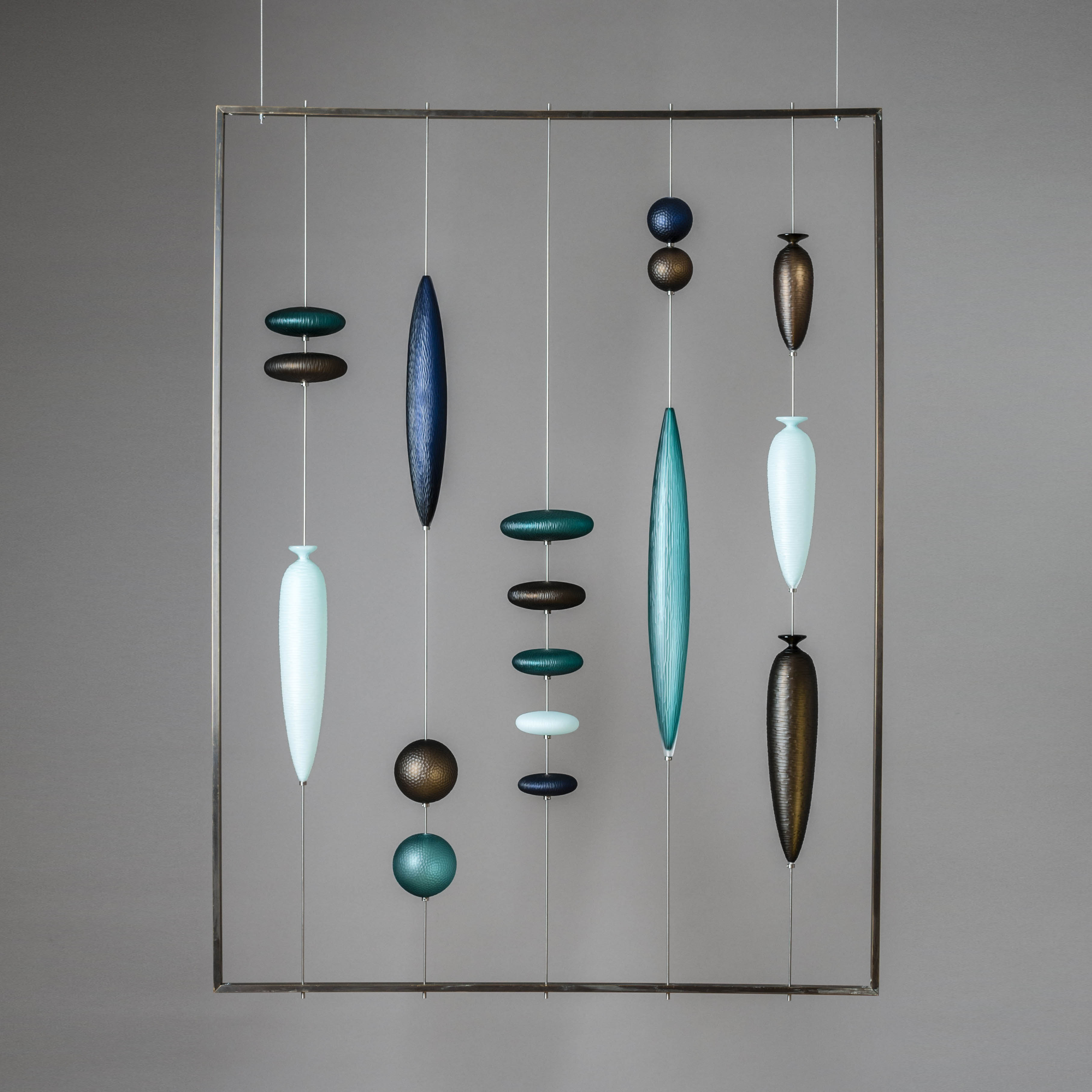 glass hanging wall artwork with small pieces held by wire inside metal frame