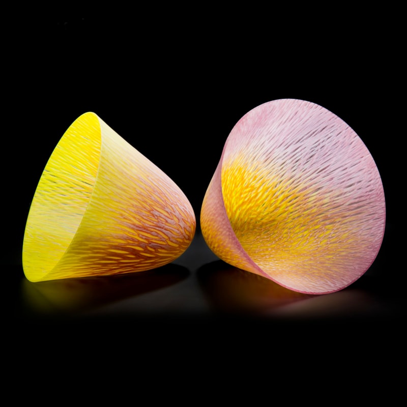 two art glass cone shaped vessels in yellow and pink