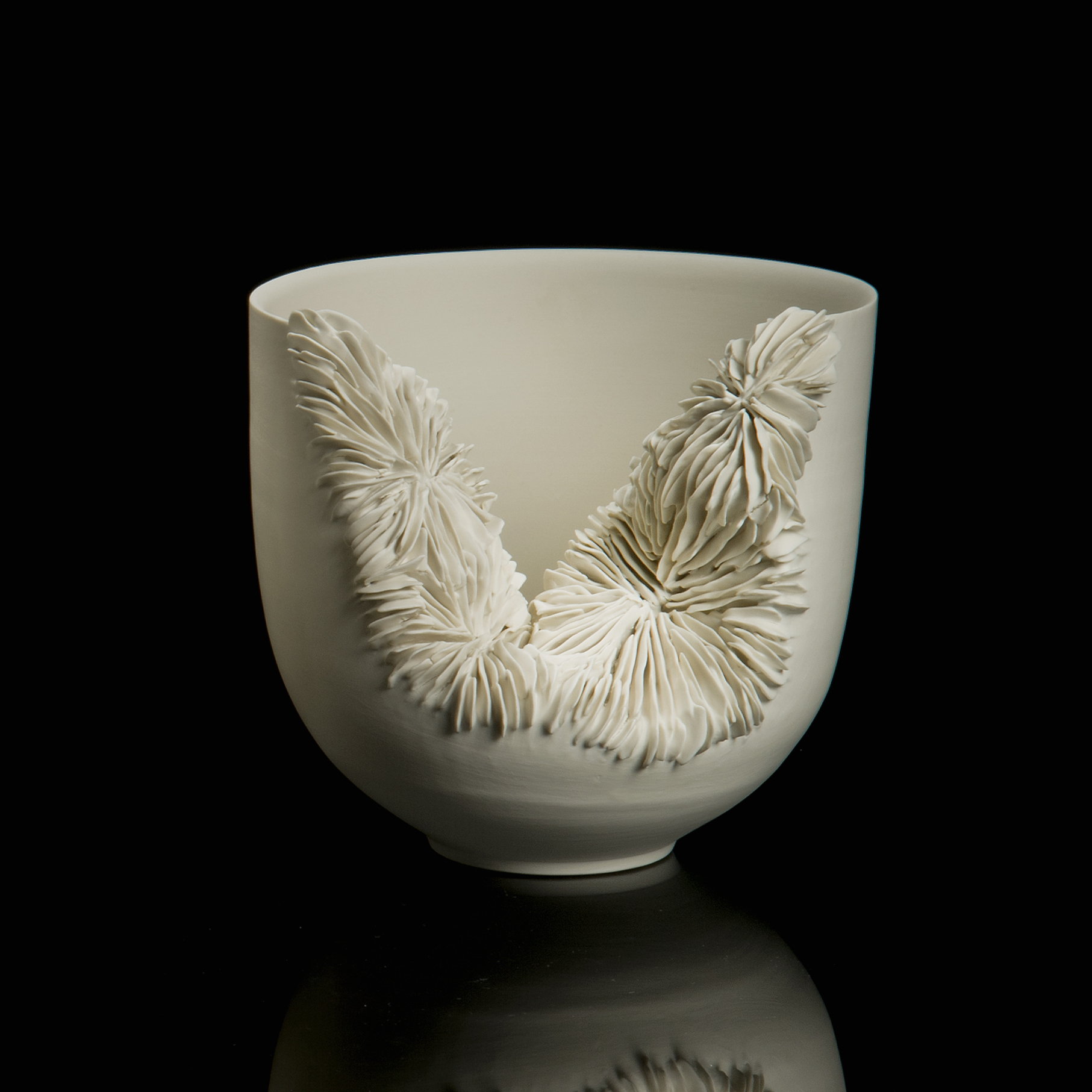 white ceramic sculpture of a tall bowl with collapsed side revealing layered pattern