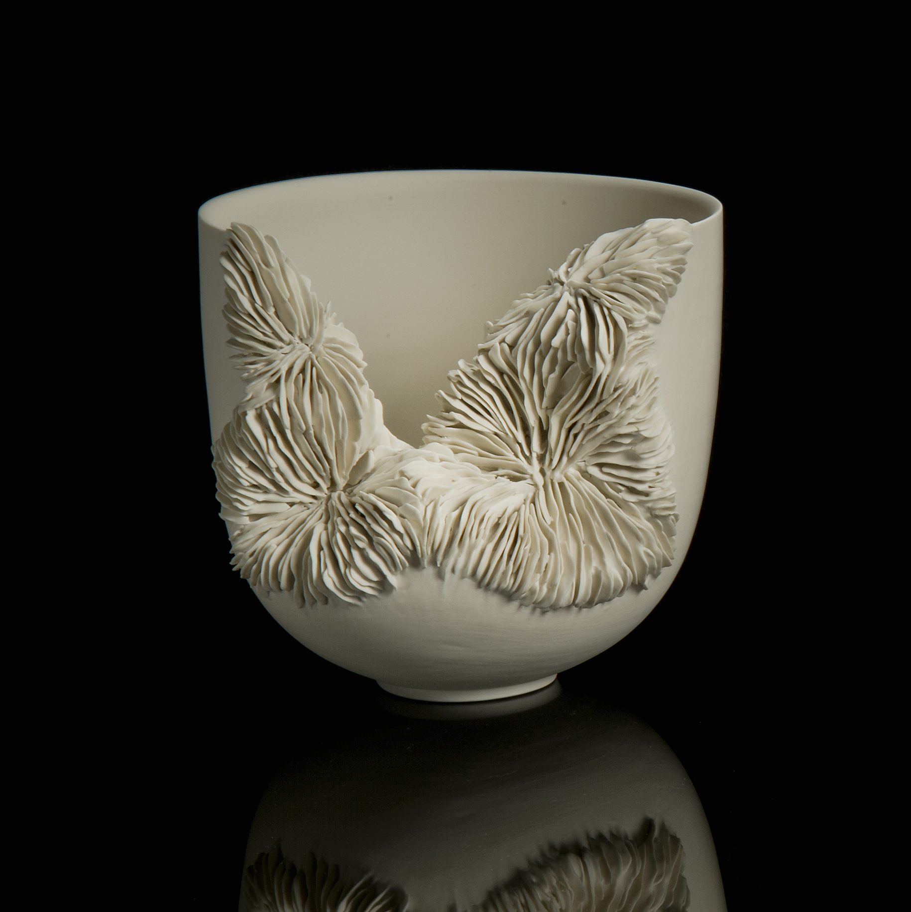 white porcelain sculpted tall bowl with collapsed side recealing complex layered pattern
