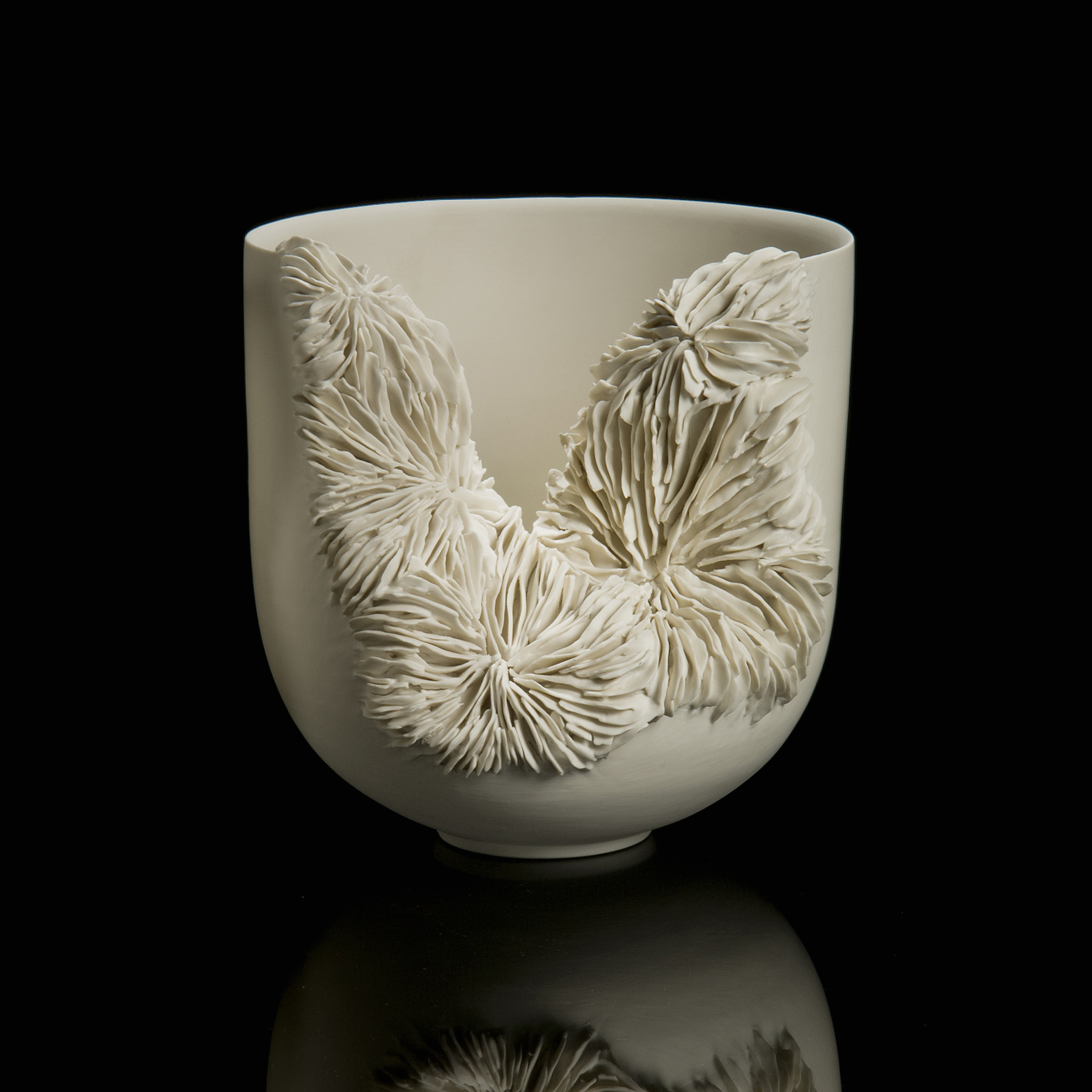 white ceramic sculpture of a tall bowl with collapsed side revealing layered pattern