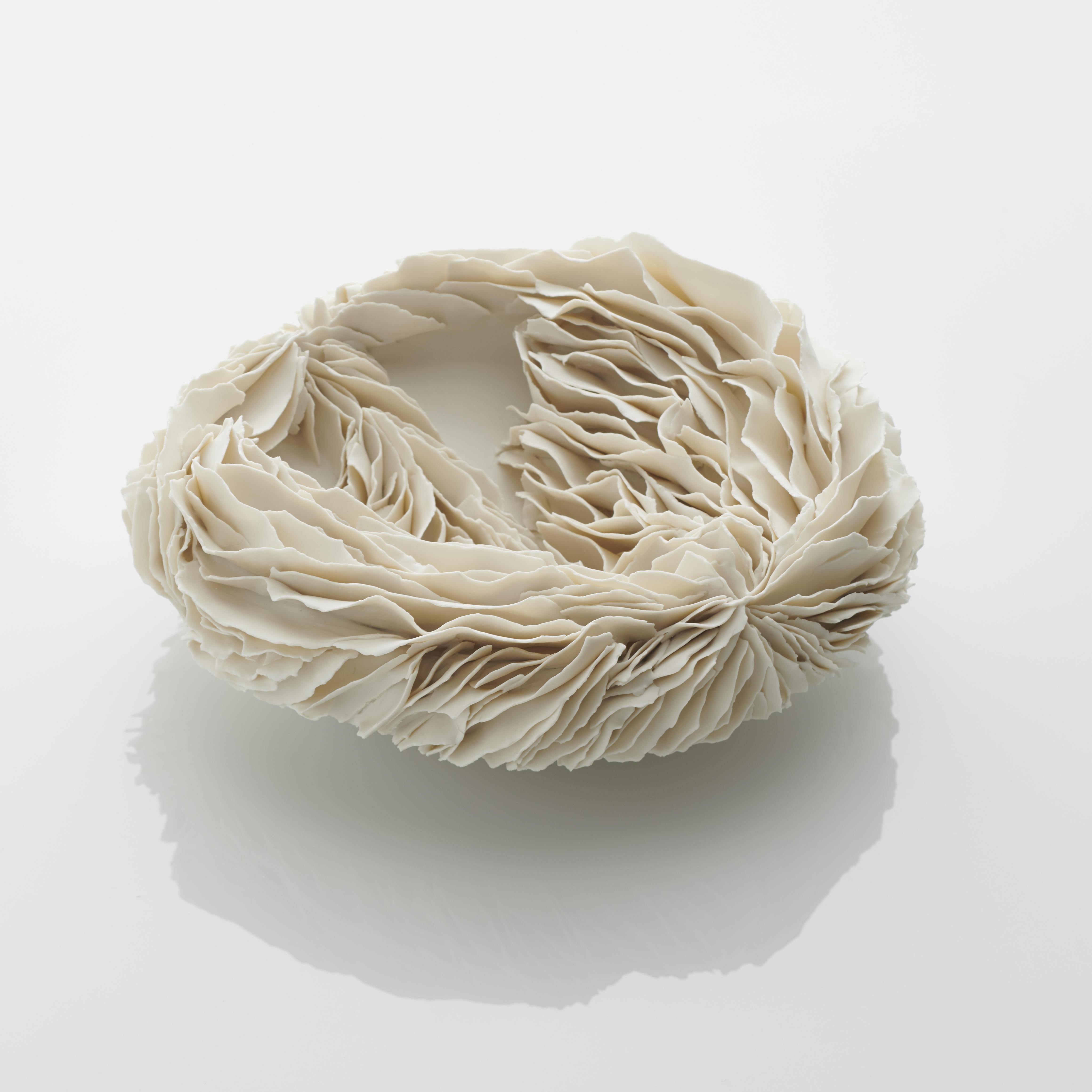 white porcelain art sculpture of flat bowl with feathered appearance