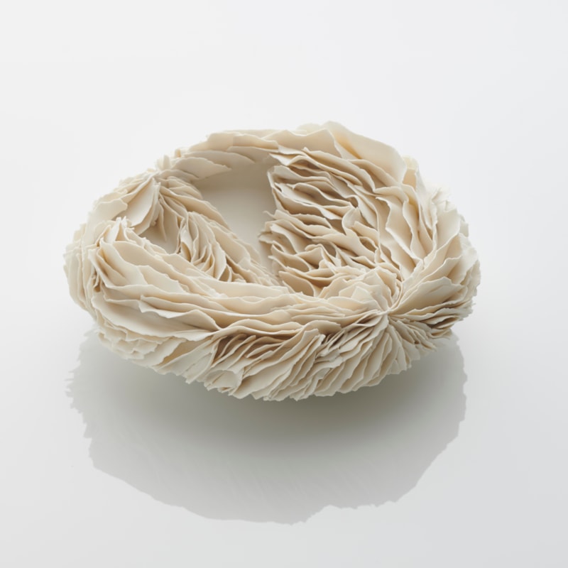 white porcelain art sculpture of flat bowl with feathered appearance
