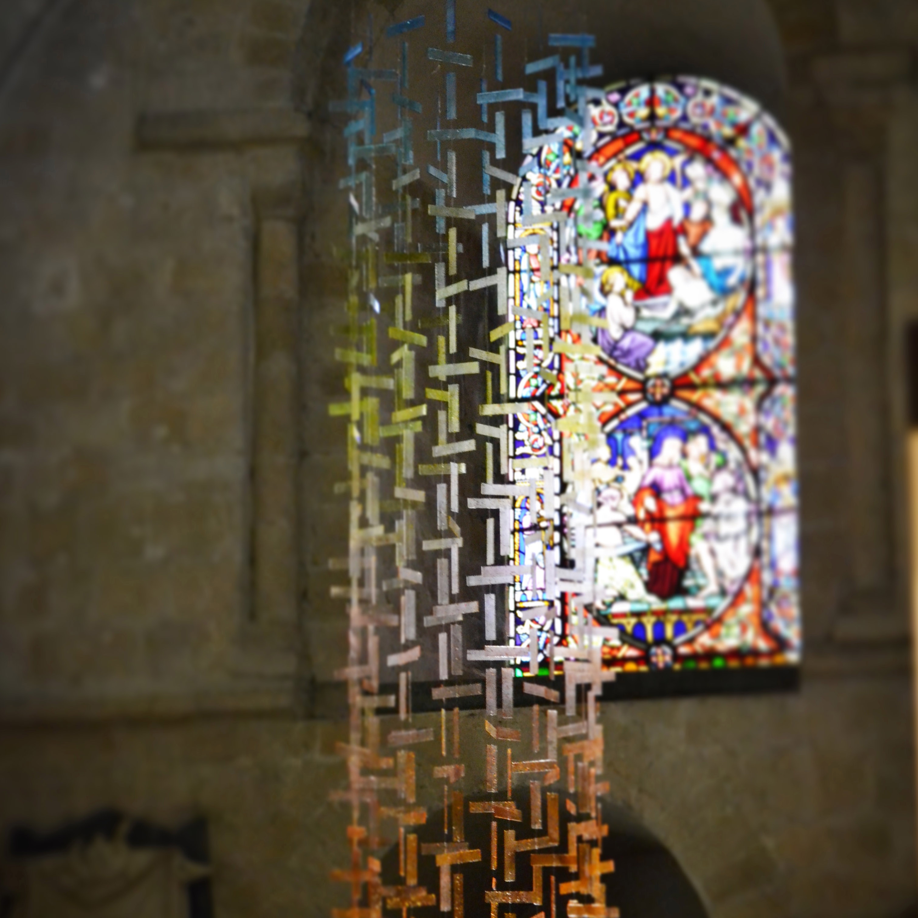 hanging glass installation from handmade fused glass components in yellow blue and orange colours