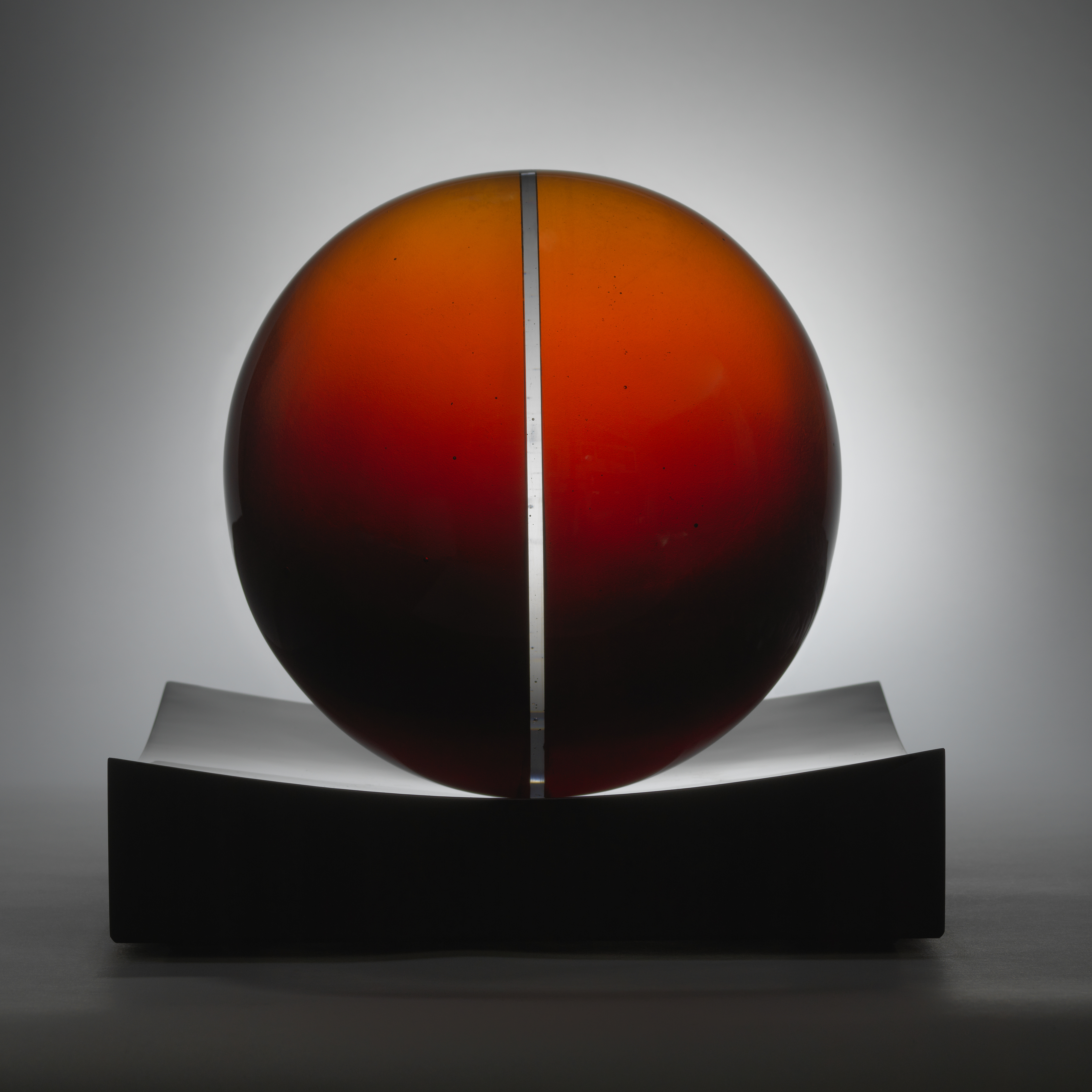 red minimalist art glass spherical sculpture with central line motif
