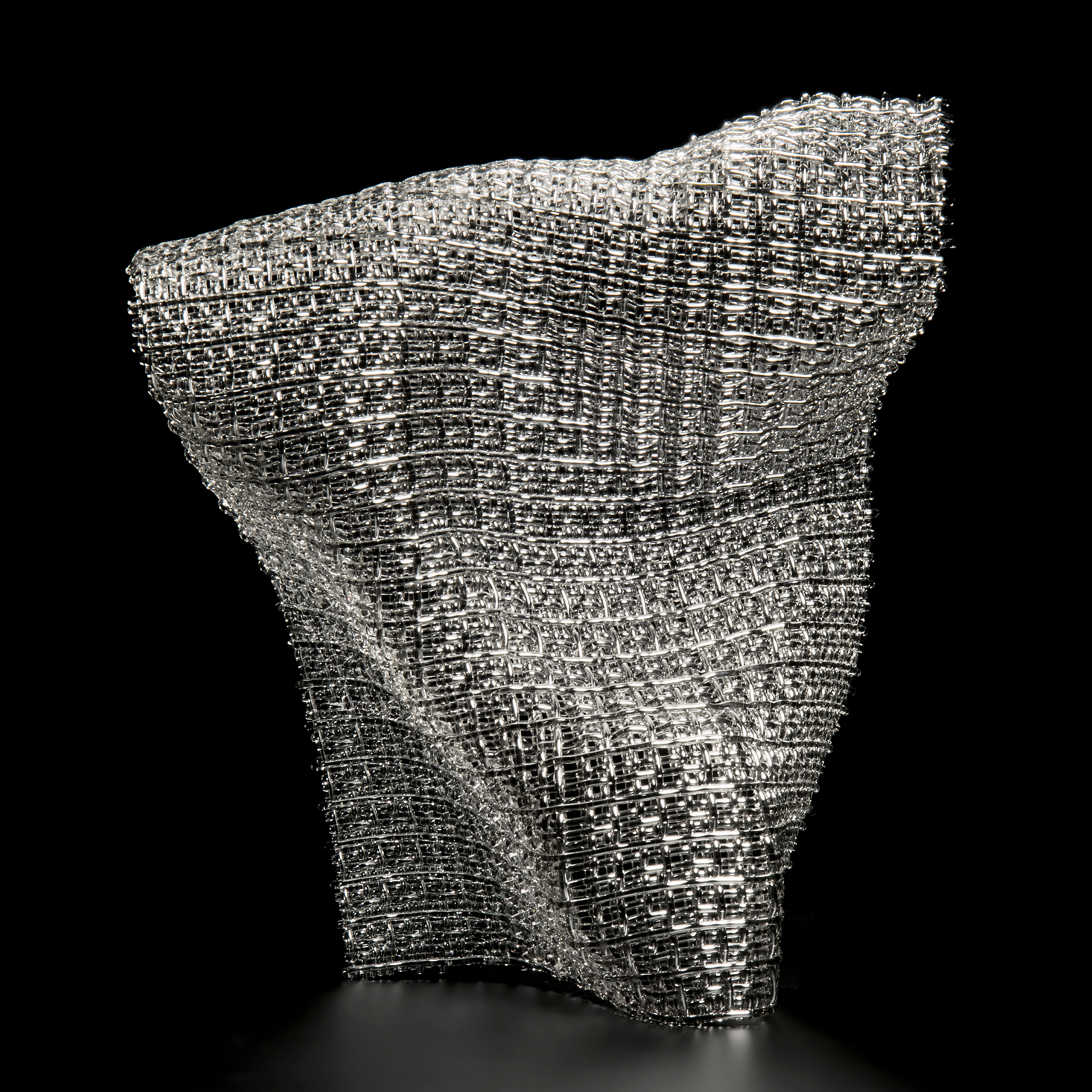 layered fused glass sculpture resembling fabric mesh