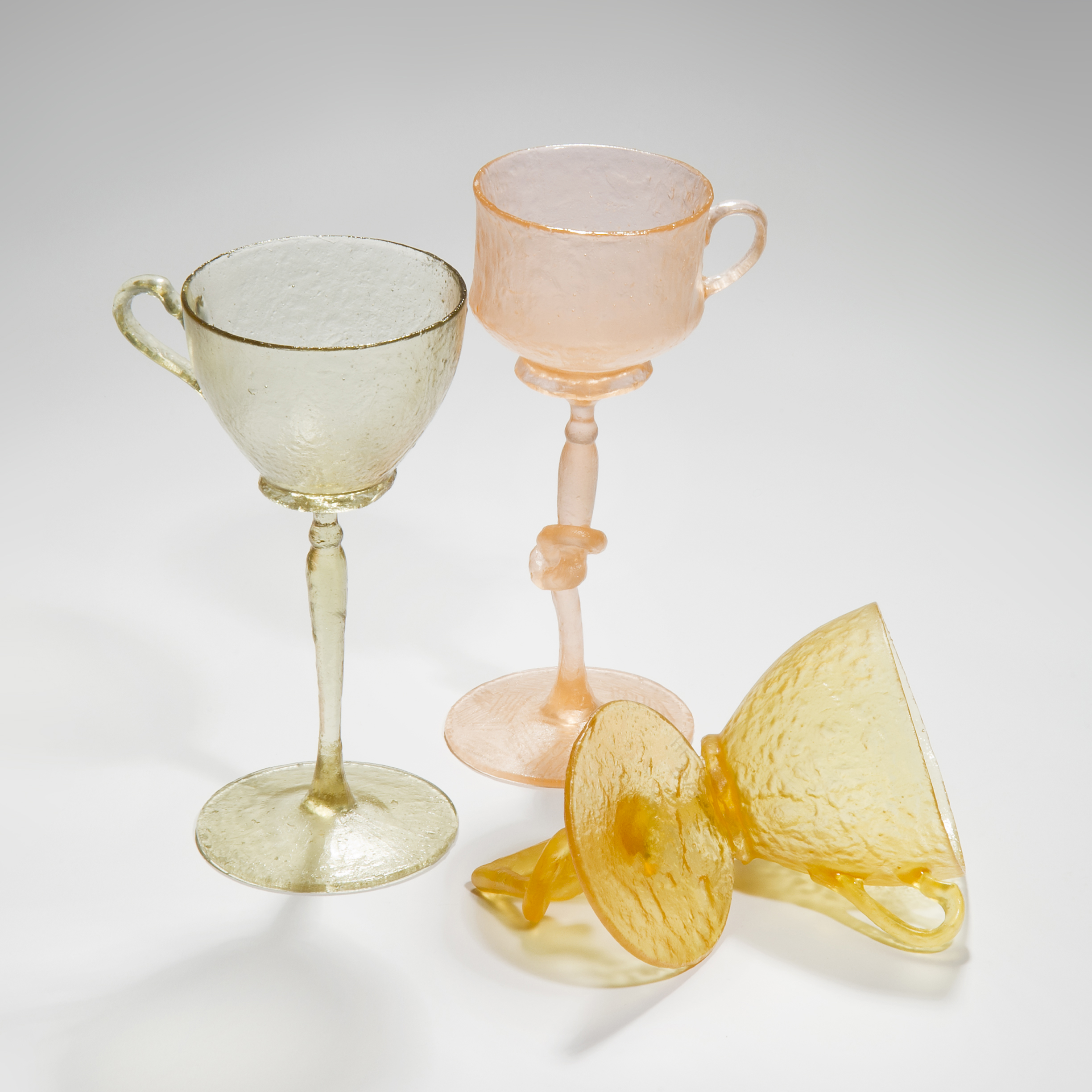 art-glass sculpture of tall glasses in green pink and orange