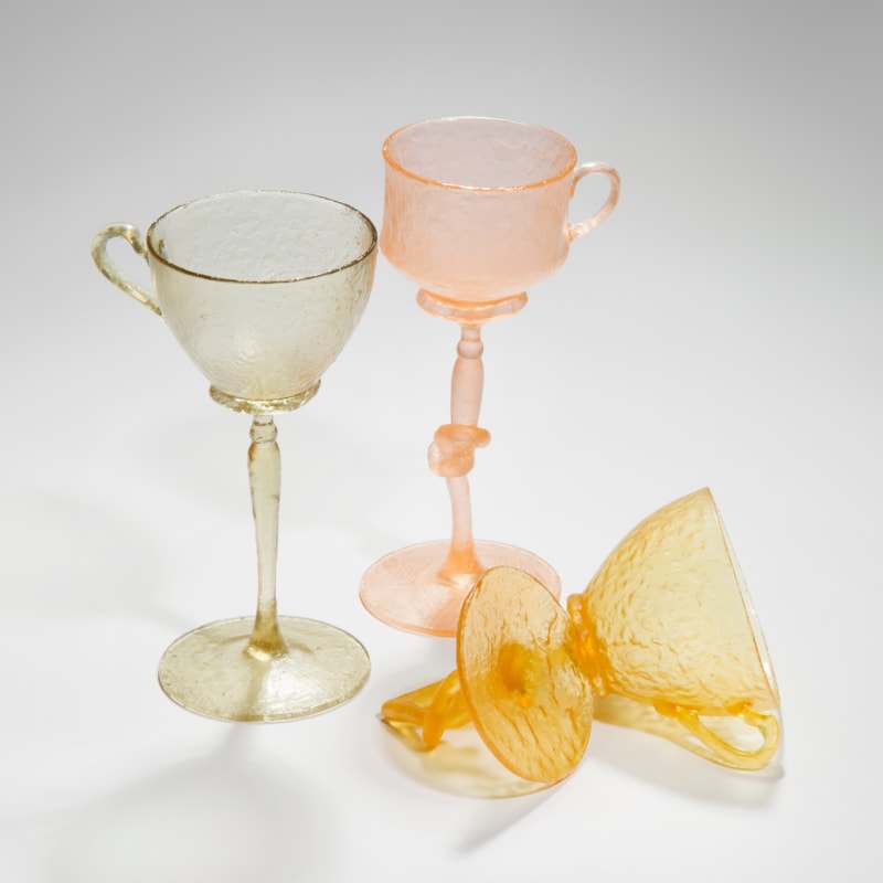 art-glass sculpture of tall glasses in green pink and orange
