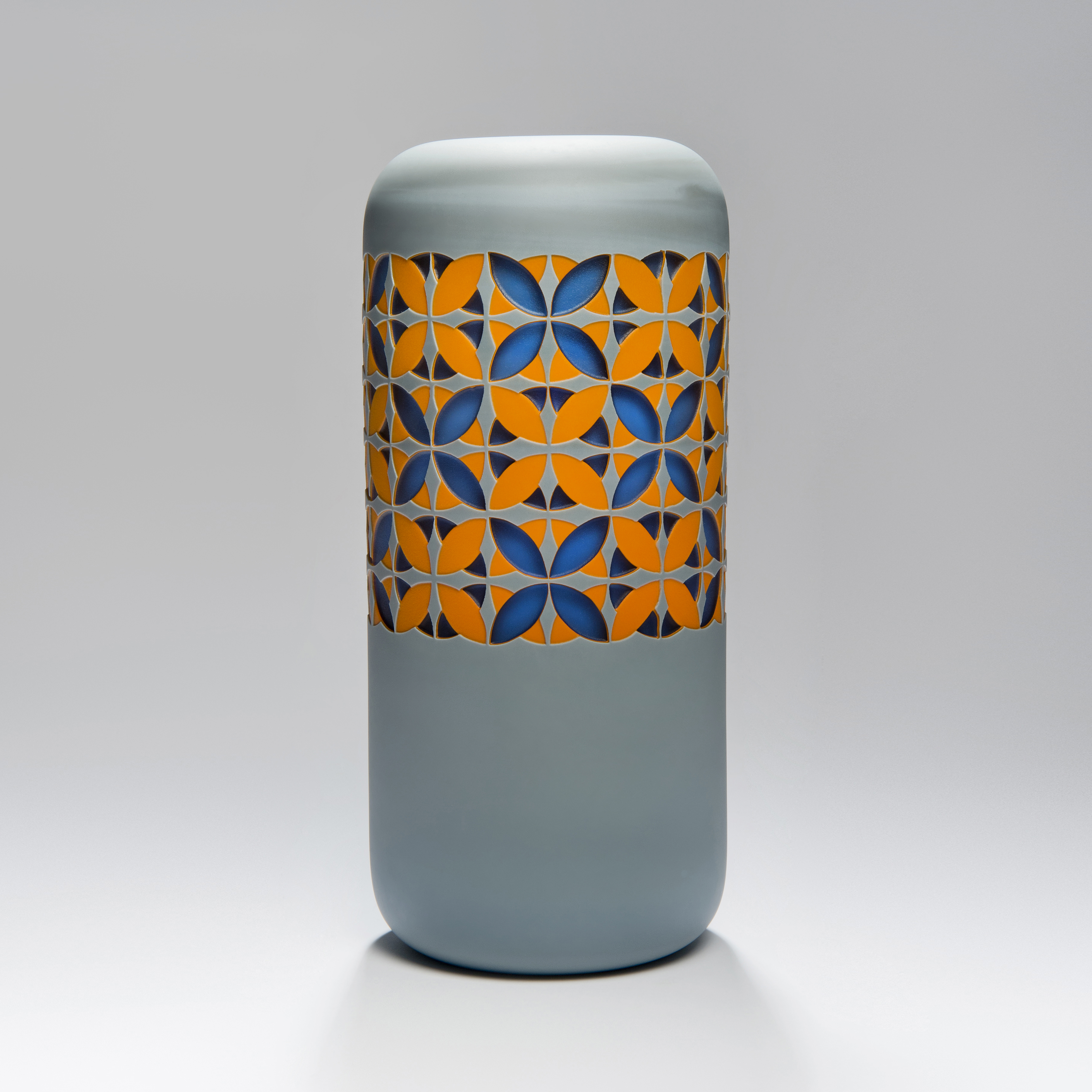 tall art glass sculpture in grey with orange and blue pattern