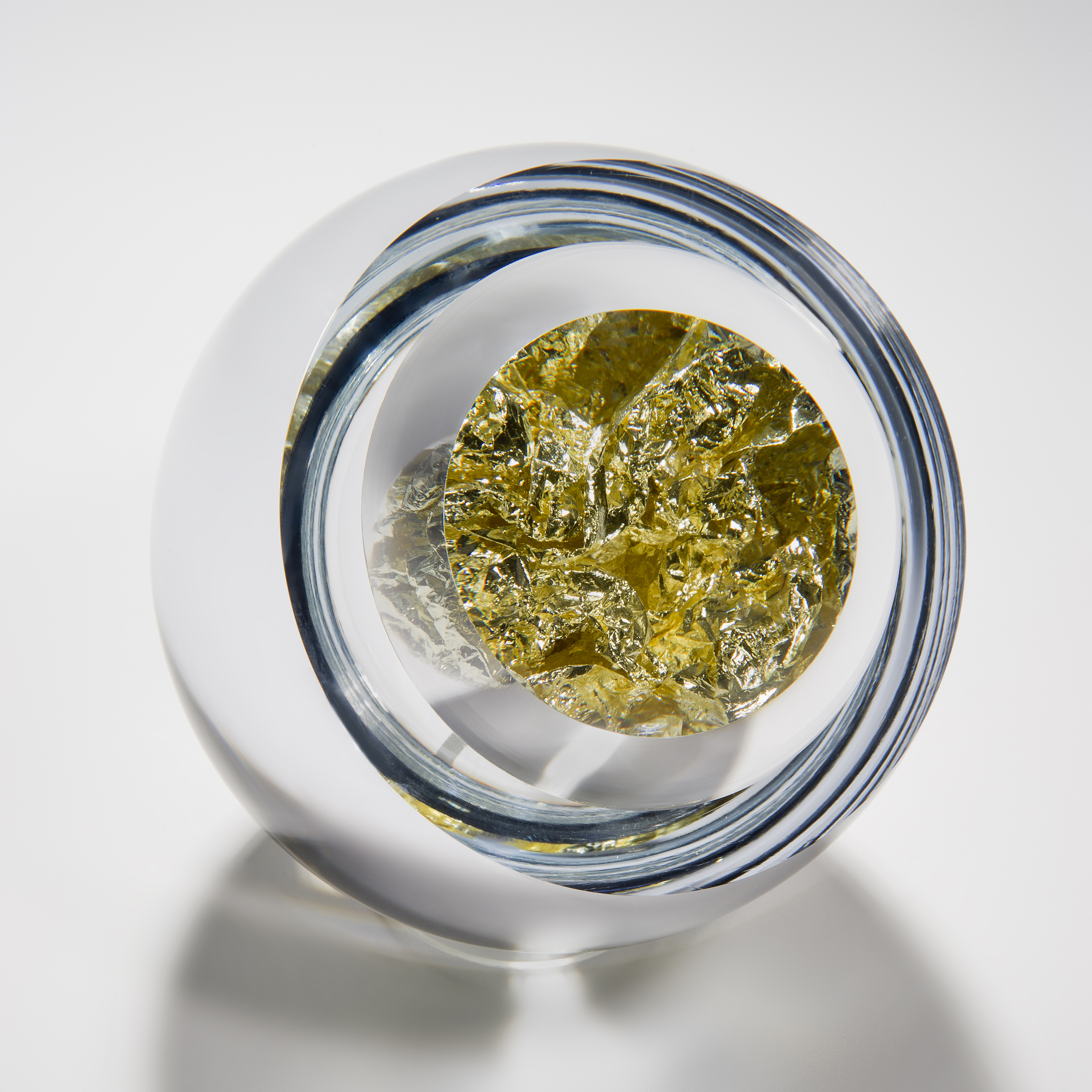 modern art glass orb sculpture with clear glass exterior and yellow gold interior