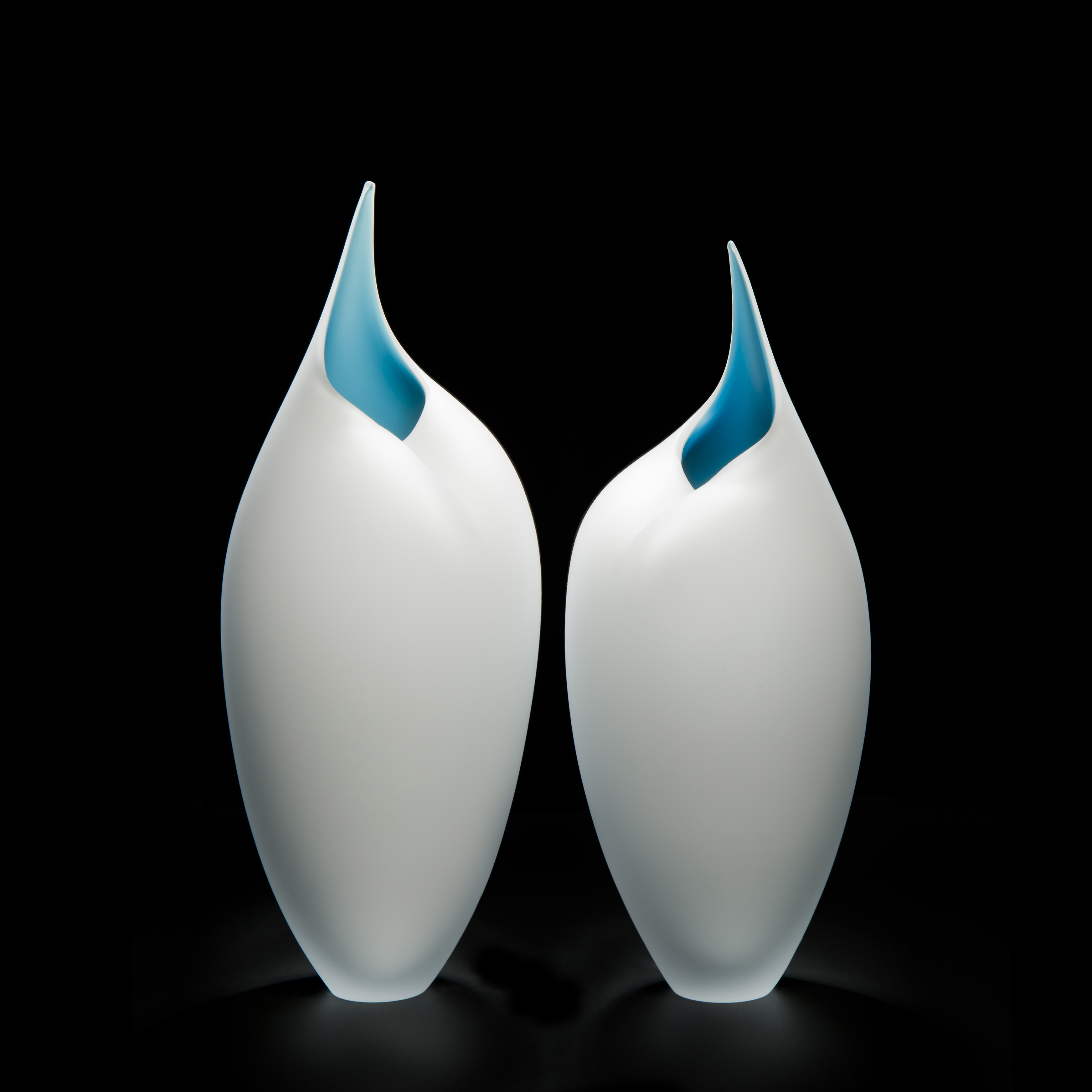 two art glass sculptures of bird like forms in white and turquoise
