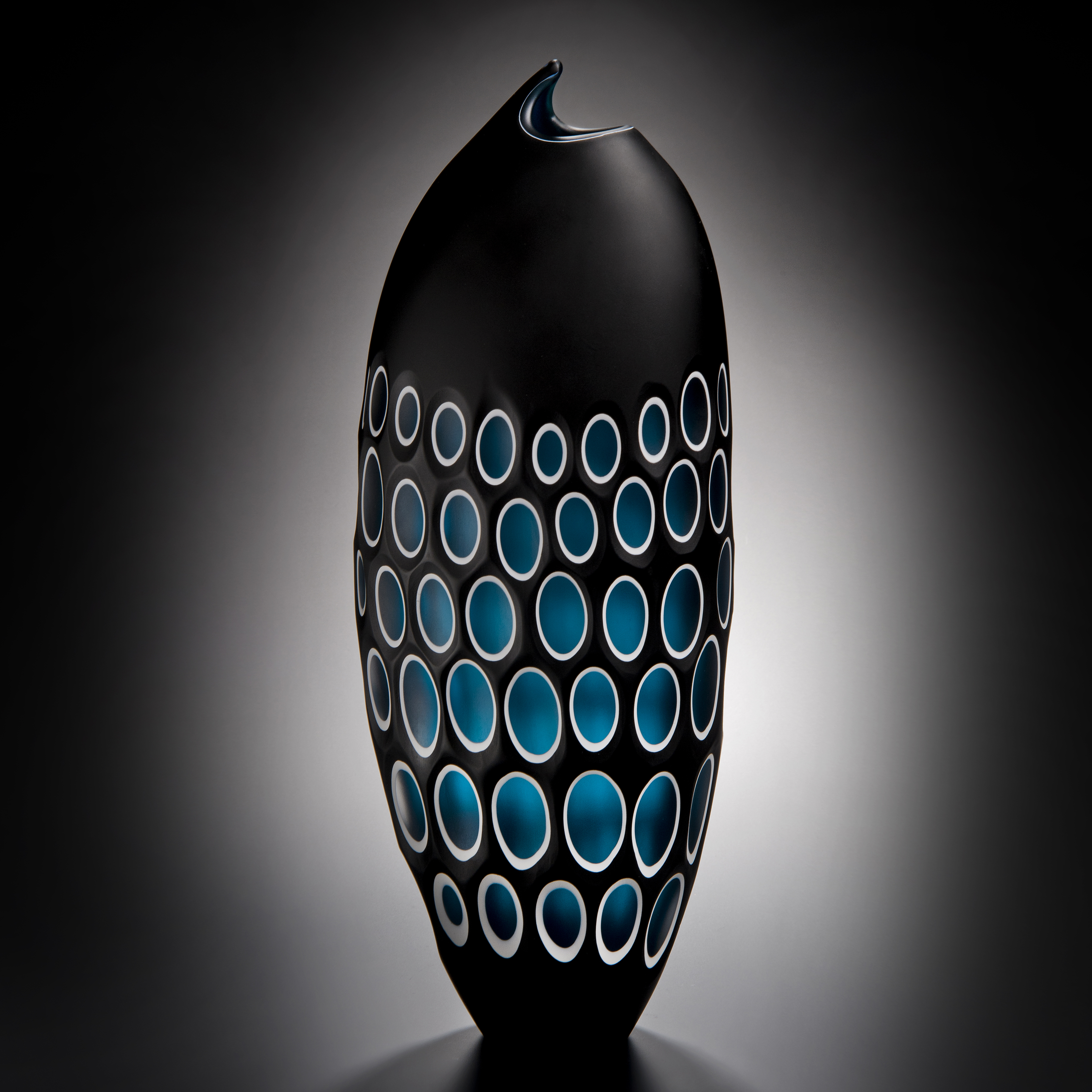 modern art glass sculpture of a fish in black with blue scales