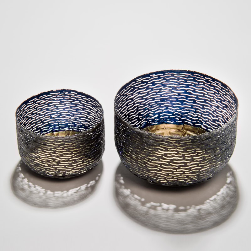 two decorative reformed steel can bowls in blue and grey with gold patterned interior and exterior