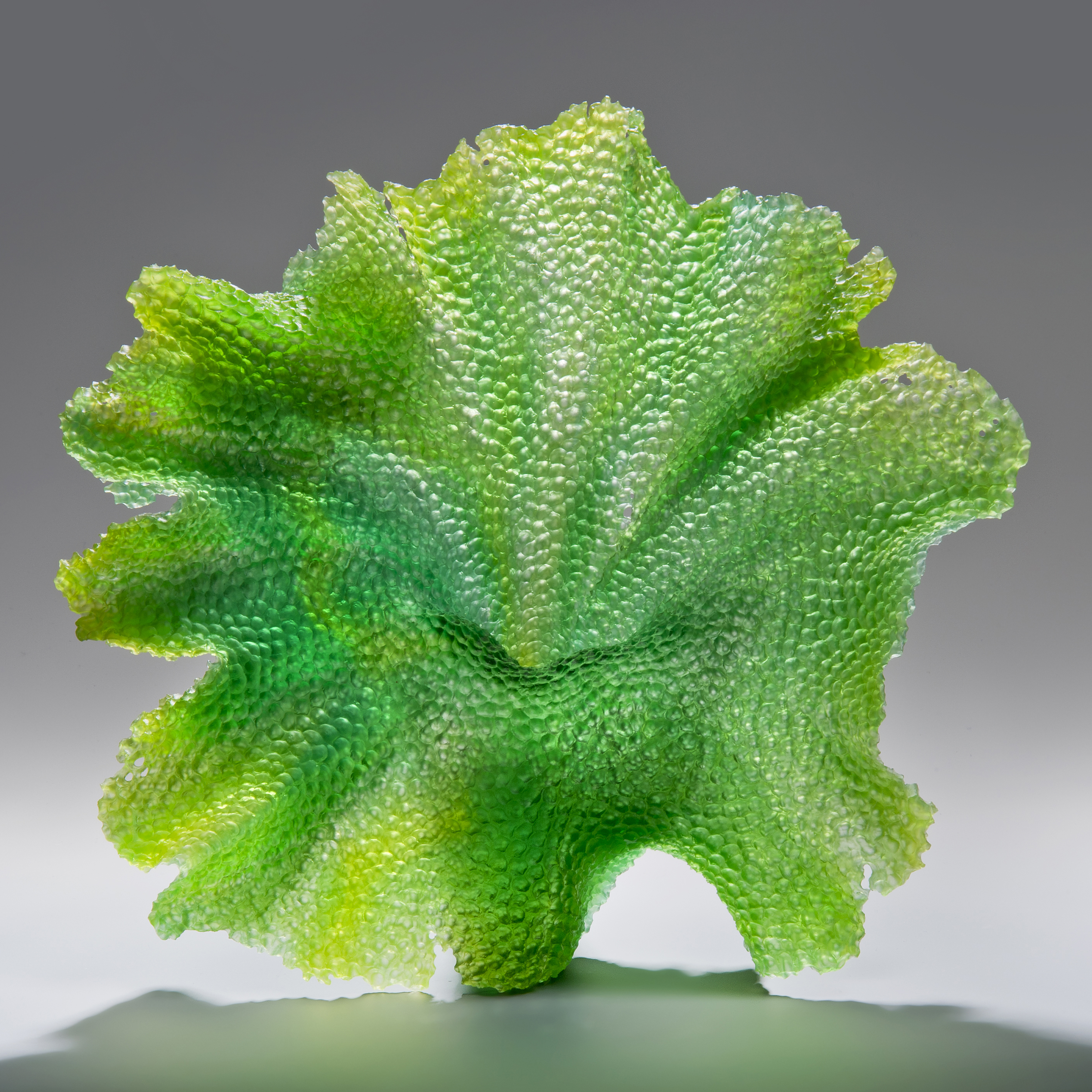 glass art sculpture of leaf in bright green