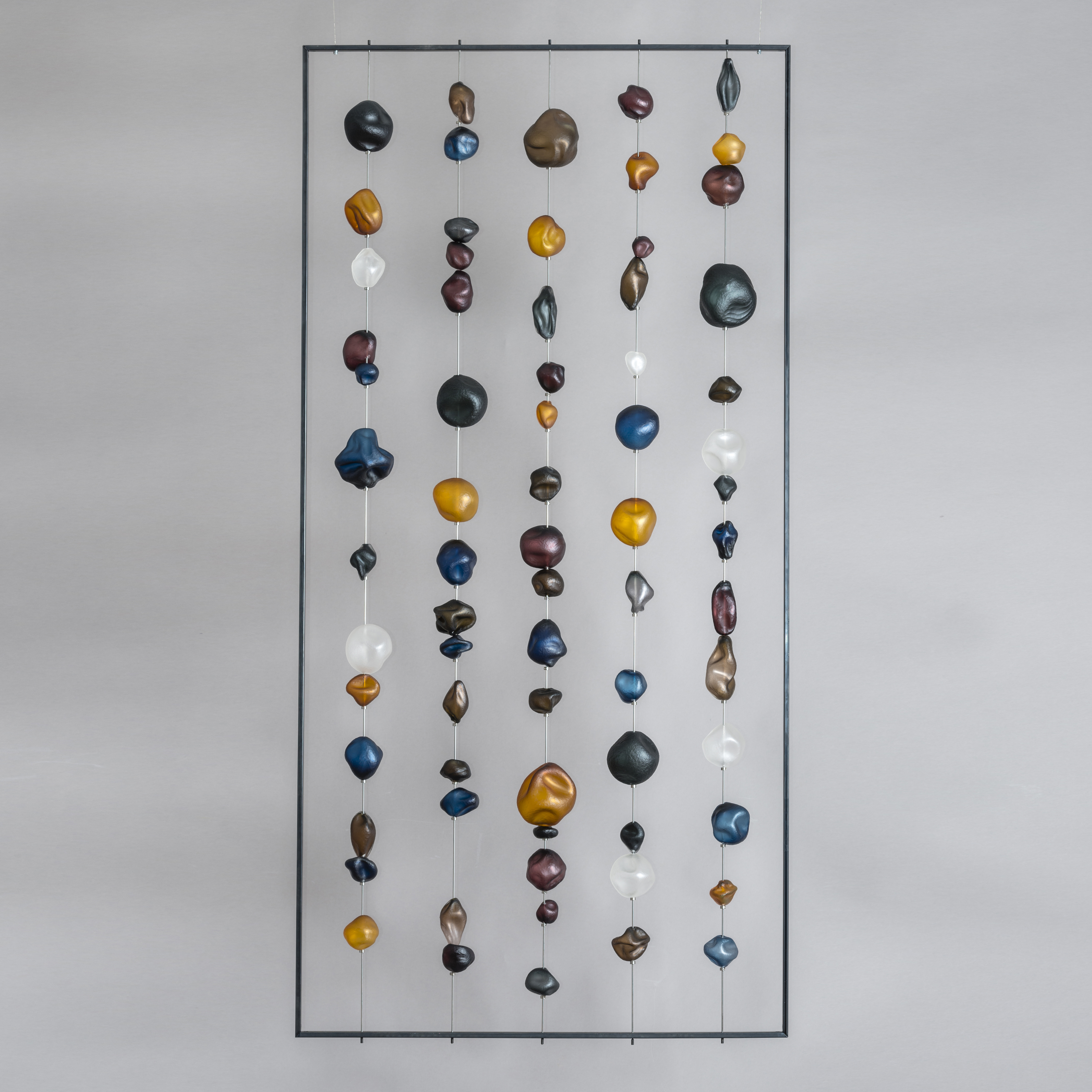 hanging art glass sculpture of brightly coloured pebble shaped glass pieces in rectangular frame