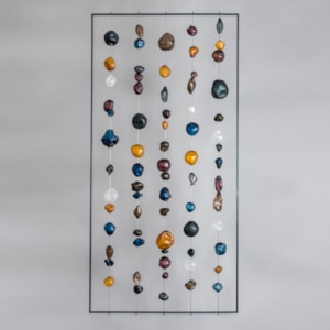 hanging art glass sculpture of brightly coloured pebble shaped glass pieces in rectangular frame