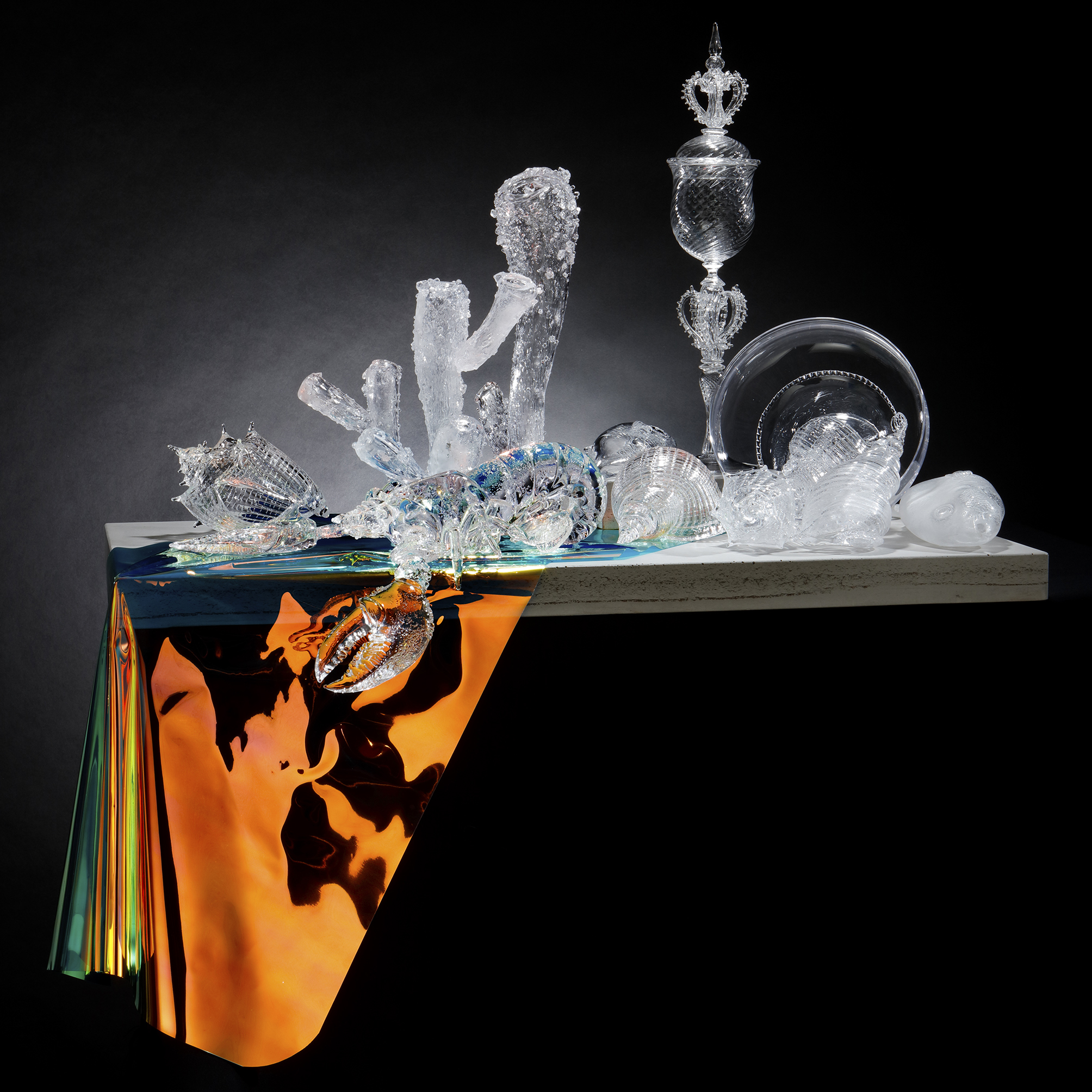 still life handblown and sculpted glass sculpture of objects on concrete table