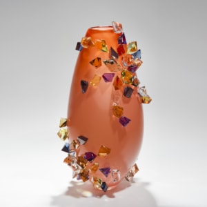 tall handblown glass-art case in peach with colored crystals adorning the outer edges